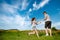 Teenagers: brother and sister are running and enjoying weather, in meadow against cloudy sky