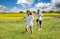 Teenagers: brother and sister are running and enjoying weather, in meadow against cloudy sky