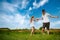 Teenagers: brother and sister are running and enjoying weather, in meadow against cloudy sky