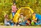 Teenagers build yellow tent themselves in forest