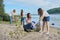 Teenagers cleaning plastic trash in nature, riverbank