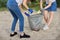 Teenagers cleaning plastic trash in nature, riverbank