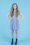 Teenagers Concepts. Sad and Depressed Teenage Girl In Long Blue Dress and Wellington Rubber Boots Posing Against Blue Background