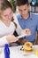 Teenagers decorating pancakes with berry