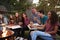 Teenagers at a fire pit eating take-away pizzas, close up