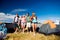 Teenagers in front of tents with backpacks, summer festival