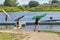 Teenagers go from river and bear kayaks on shoulders, Belarus.