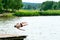 Teenagers jump into the water and swim in the lake on a hot summer day. Active recreation on an open pond. Children jump into the