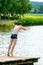 Teenagers jump into the water and swim in the lake on a hot summer day. Active recreation on an open pond. Children jump into the