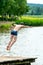 Teenagers jump into the water and swim in the lake on a hot summer day. Active recreation on an open pond. Children jump into the