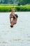 Teenagers jump into the water and swim in the lake on a hot summer day. Active recreation on an open pond. Children jump into the