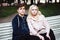 Teenagers in love sit on a Park bench in autumn and stare straight ahead