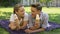 Teenagers lying on plaid in park and eating ice-cream, romantic date outdoors