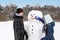 teenagers make a snowman. The concept of active winter recreation.