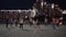 Teenagers play volleyball in the middle of a big night city. Evening lights