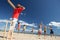 Teenagers playing cricket on beach