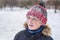 A teenagers portrait â€“ a close-up of a happy boy in winter at the snow background. The whole face in the snow