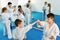 Teenagers practicing new karate moves in pairs in class