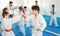 Teenagers practicing new karate moves in pairs in class