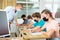 Teenagers in protective masks making notes of teacher lecture in college