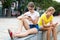 Teenagers share information with each other from smartphones while relaxing on street