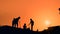 Teenagers silhouette resting and communicating against orange sunset sky