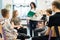 Teenagers sitting in a circle in front of them facing the nurse with a green notebook