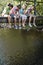 Teenagers Sitting On Wooden Bridge Looking Down At Stream