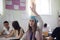 Teenagers student girl sitting in the classroom and raising hand