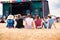 Teenagers, summer music festival, sitting in front of stage