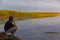 Teenboy sitting and relaxing on lake beach