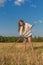 Teengirl with a scythe at summer field
