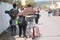 Teens going to the campsite of a music festival with their luggage, on a hot sunny summer day