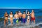 Teens group running happy splashing on the beach