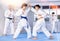 Teens in kimonos honing punches during kumite at karate training