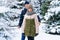 Teens portrait in a winter forest, boy and girl, beautiful nature with bright snowy fir trees