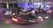 Teens ride carnival bumper cars at night