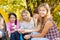 Teens sit on campsite with marshmallow sticks