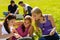 Teens studying in park reading book students