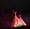 Teepee With Red Light Against A Dark Sky