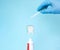 Teeth care and protection concept. Closeup. Doctors hands in blue gloves hold glass tube with calcium under Toothpaste tube and