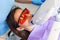 Teeth whitening procedure for pretty happy female patient in a dental clinic