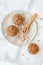 Teff hazelnut muffins on a plate with a scooper filled with hazelnuts.