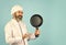 Teflon might be toxic. Nonstick pan for frying. Enameled cooking vessels. Man hold pan. Frying meal. Healthy food