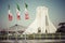 TEHERAN, IRAN - OCTOBER 03, 2016: Azadi Tower with flasgs of Ira