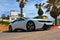 Tel-Aviv, Israel - 15.02.2018: White BMW i8 car parked on the street near white house and palm trees. Luxury hybrid vehicle
