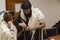 TEL AVIV, ISRAEL - 19 JANUARY 2018: An orthodox man, wearing prayer shawl, put a Jewish Tefillin on A young man arm