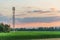 Telecom antenna in countryside in summer at sunset