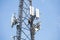 Telecom maintenance. Two repair men climbing on tower against blue sky background