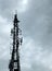 Telecommunication mast in silhouette against clouds with 2g 3g and 4g gsm mobil pone antennas relay equipment and terrestrial tv